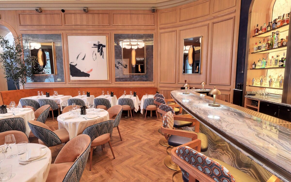 The sweeping marble bar with banquette seating and bottle display