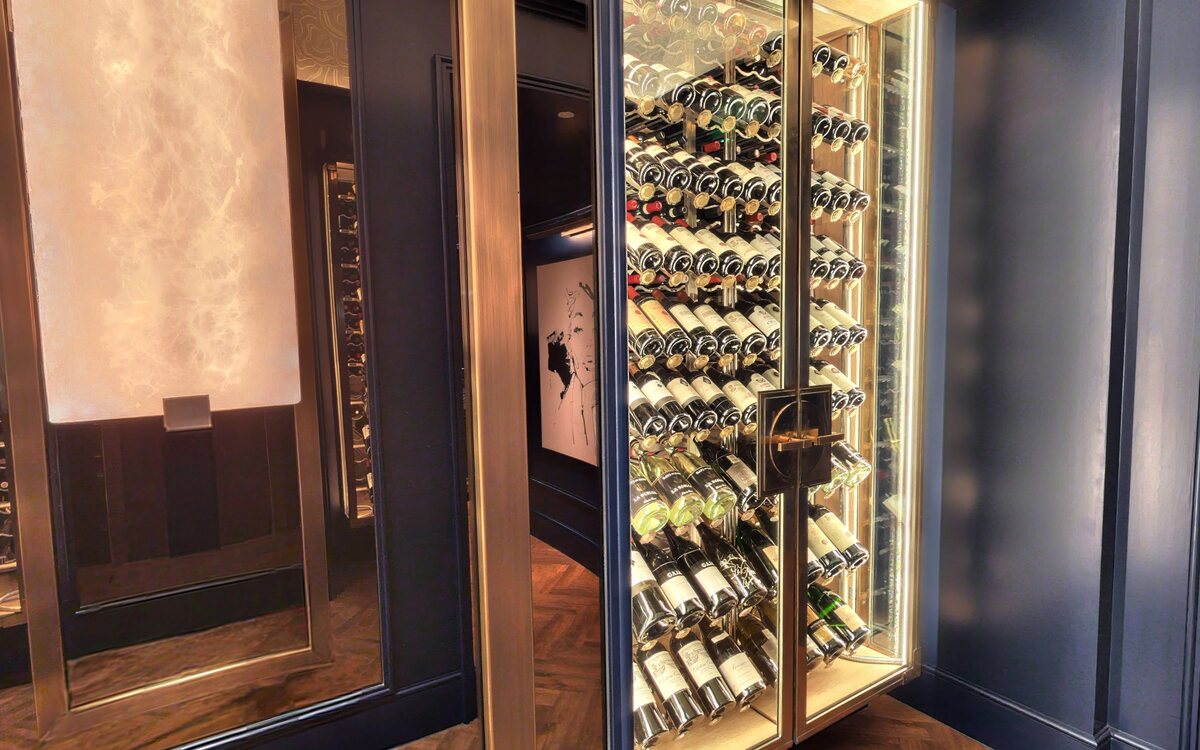 The wine room with backlit onyx and floor-to-ceiling racks
