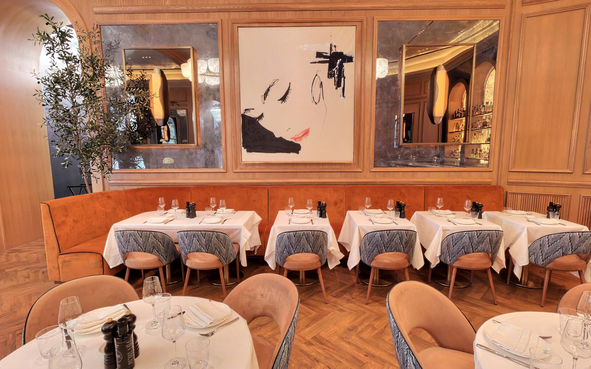 The main dining hall with orange banquettes and gallery artwork